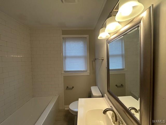 bathroom featuring baseboards, vanity, toilet, and crown molding