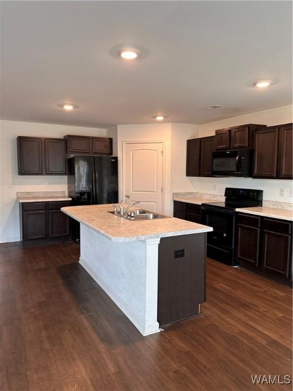 kitchen with black appliances, a center island with sink, sink, dark hardwood / wood-style floors, and dark brown cabinets