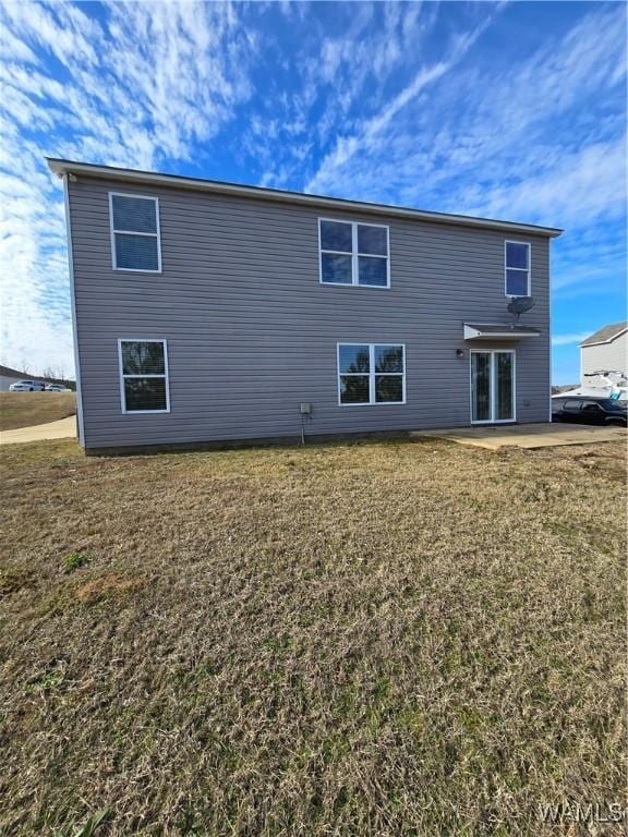 rear view of property featuring a patio area and a yard