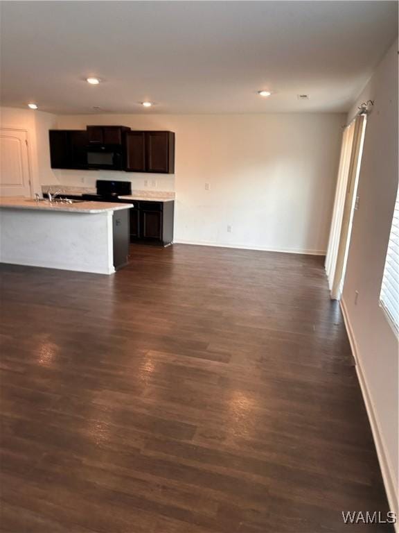 kitchen featuring a kitchen island with sink and dark wood-type flooring