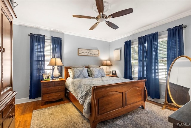 bedroom with light hardwood / wood-style floors, ceiling fan, and crown molding