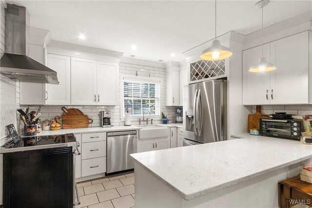 kitchen featuring white cabinetry, sink, wall chimney range hood, kitchen peninsula, and appliances with stainless steel finishes