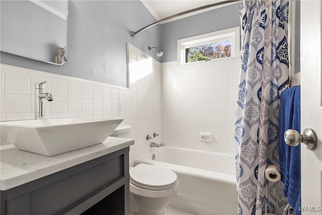 full bathroom with shower / tub combo with curtain, vanity, tile walls, and toilet