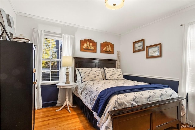 bedroom with crown molding and light hardwood / wood-style flooring