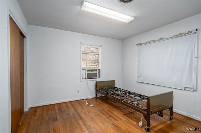 interior space with cooling unit and hardwood / wood-style flooring