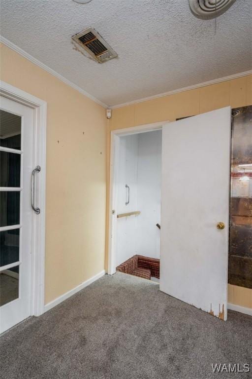 unfurnished room with ornamental molding, carpet floors, and a textured ceiling