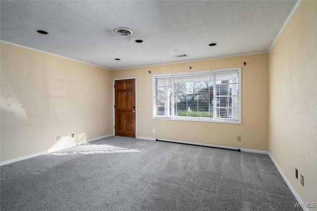 carpeted empty room featuring ornamental molding and a textured ceiling