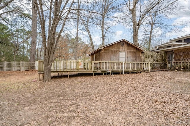 back of property with a wooden deck and an outdoor structure