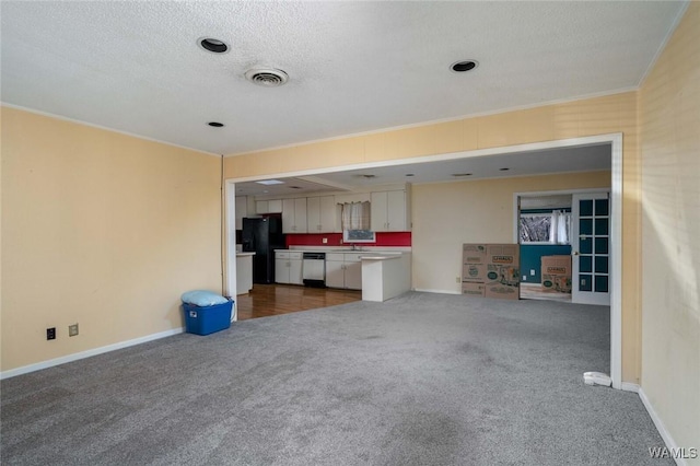 unfurnished living room with ornamental molding, a textured ceiling, and dark colored carpet