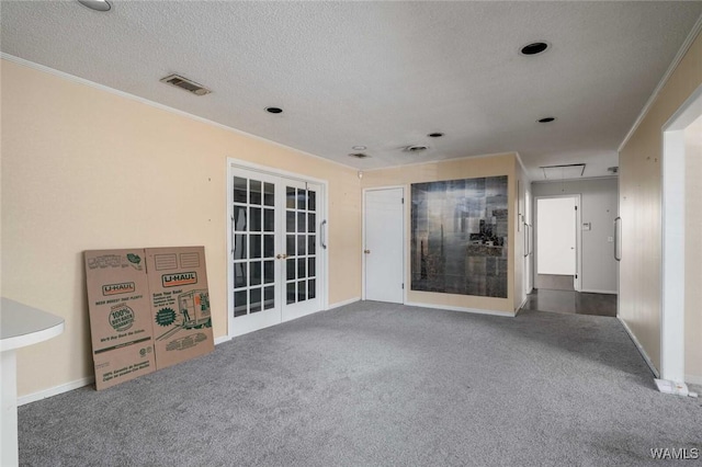 spare room with french doors, crown molding, carpet floors, and a textured ceiling