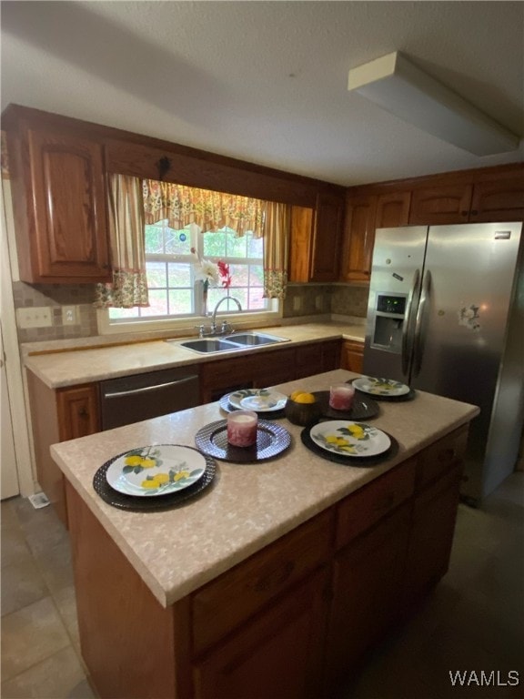 924 12th St SW, Fayette, AL 35555 - kitchen featuring a sink, stainless steel appliances, light countertops, and brown cabinetry