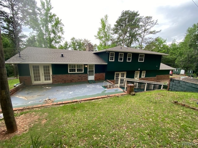 924 12th St SW, Fayette, AL 35555 - back of property featuring french doors, a patio area, a lawn, brick siding, and a chimney