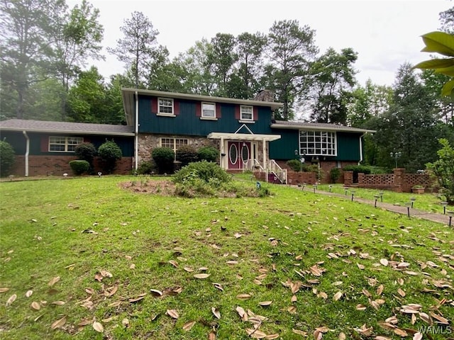 924 12th St SW, Fayette, AL 35555 - split level home featuring a front lawn, a chimney, and stone siding