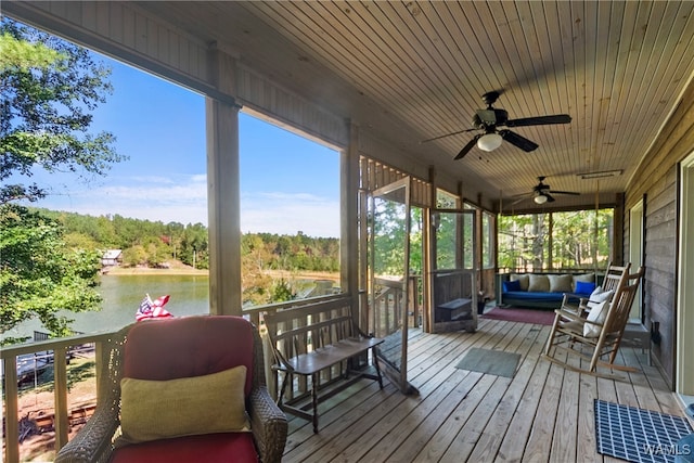 deck with ceiling fan and a water view