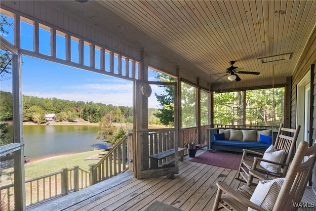 sunroom featuring ceiling fan, a water view, and wood ceiling