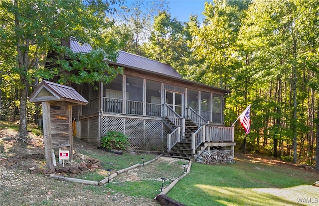 view of front of home featuring a sunroom and a front yard