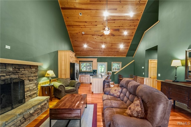 living room featuring hardwood / wood-style floors, wood ceiling, a fireplace, and high vaulted ceiling