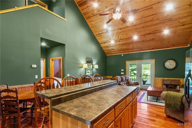 kitchen with french doors, wood ceiling, high vaulted ceiling, light hardwood / wood-style floors, and a kitchen island