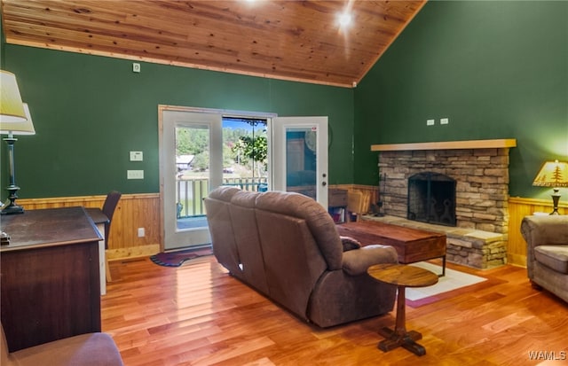 living room with a fireplace, high vaulted ceiling, wooden ceiling, and light hardwood / wood-style floors