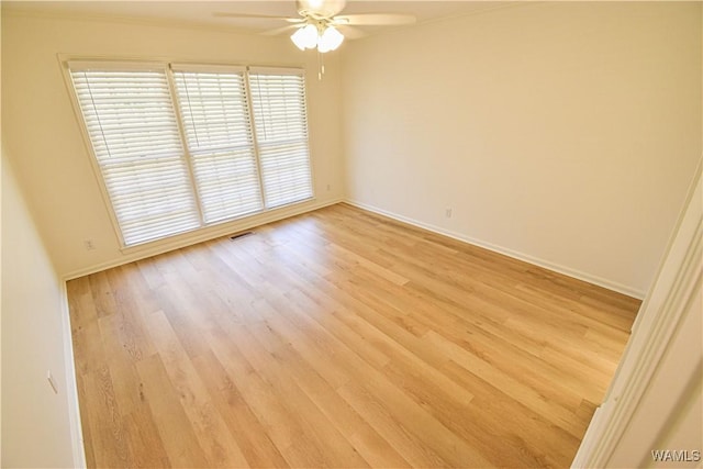 unfurnished room featuring light wood-style flooring, visible vents, baseboards, and ceiling fan