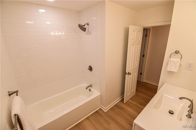 full bath with baseboards, vanity,  shower combination, and wood finished floors