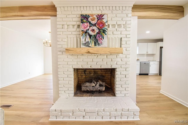 details featuring wood finished floors, visible vents, baseboards, a fireplace, and appliances with stainless steel finishes