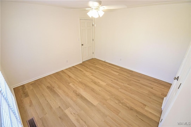 spare room with light wood finished floors, visible vents, ceiling fan, and baseboards