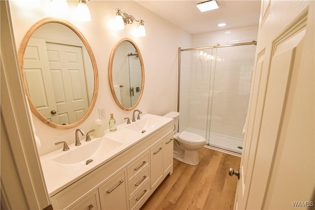 full bathroom with a sink, a stall shower, and wood finished floors