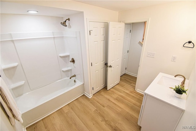 full bathroom with vanity, wood finished floors, and washtub / shower combination