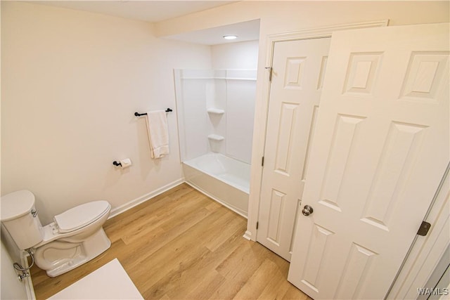 bathroom featuring baseboards, toilet, and wood finished floors