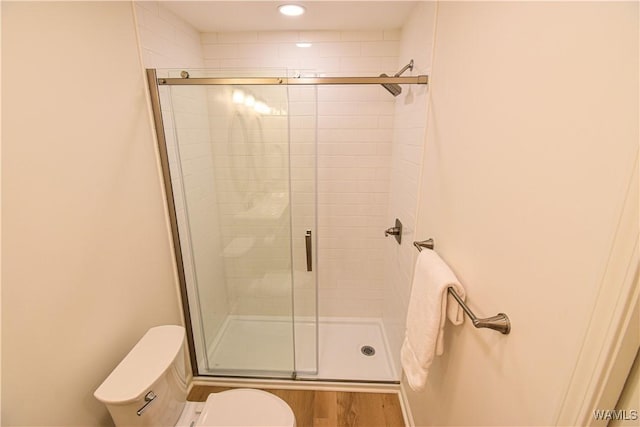 full bathroom featuring recessed lighting, toilet, wood finished floors, and a stall shower