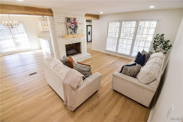 living room featuring recessed lighting, visible vents, a brick fireplace, and light wood finished floors