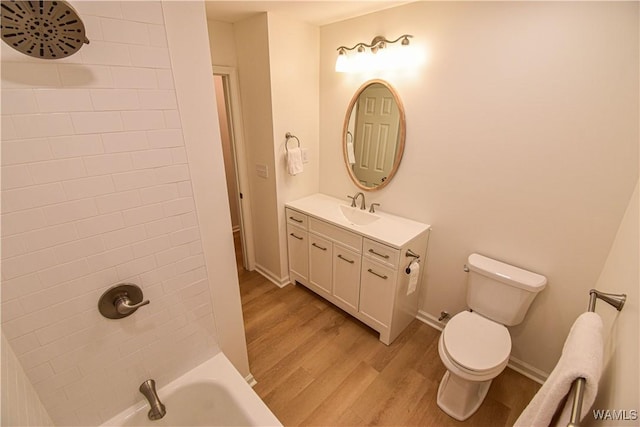 full bathroom featuring vanity, wood finished floors, baseboards, shower / washtub combination, and toilet