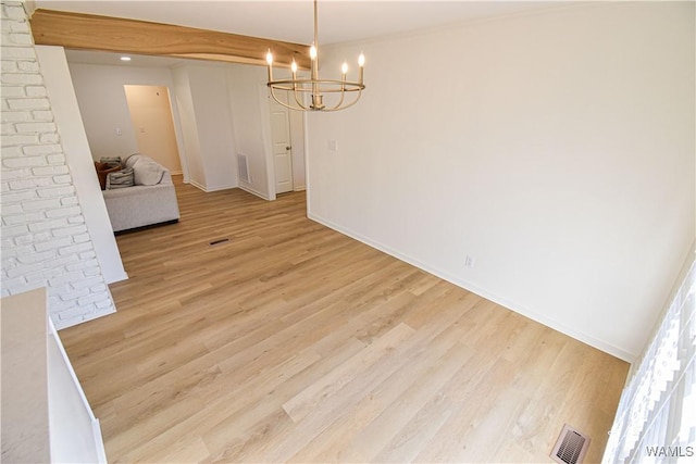 unfurnished room featuring light wood finished floors, a chandelier, baseboards, and visible vents