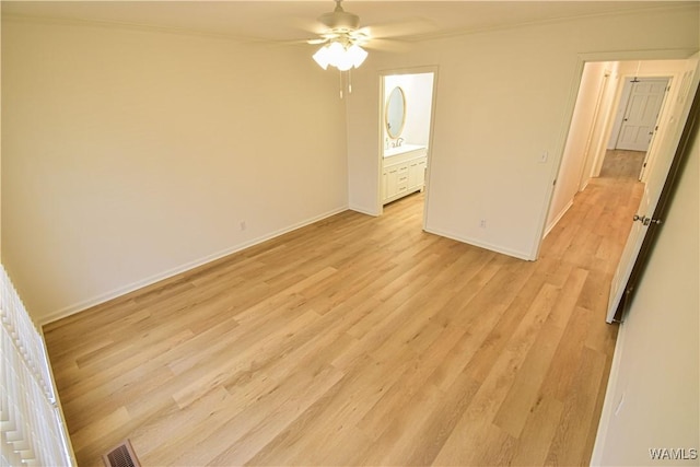 unfurnished bedroom with visible vents, baseboards, ensuite bath, and light wood finished floors