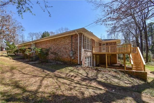 view of side of home featuring brick siding, a deck, and stairs