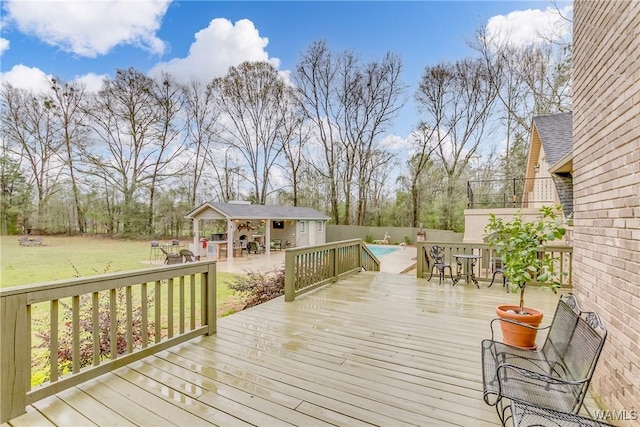 wooden deck with a fenced in pool, an outbuilding, an exterior structure, a lawn, and outdoor dining space