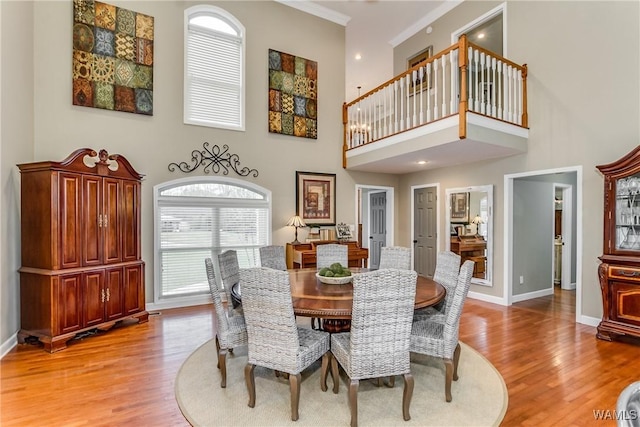 dining area with light wood-type flooring, crown molding, and baseboards