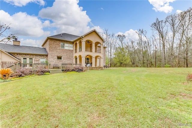 back of house with a deck and a yard