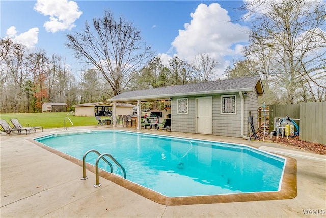 view of pool featuring a fenced in pool, a patio, a lawn, fence, and an outdoor structure