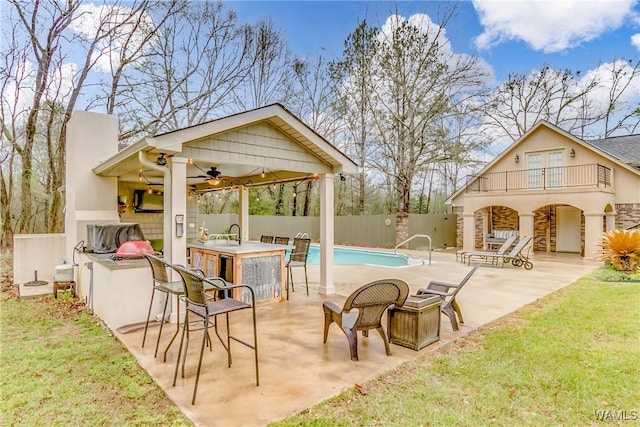 view of pool featuring a fenced in pool, a ceiling fan, a patio, outdoor dry bar, and fence