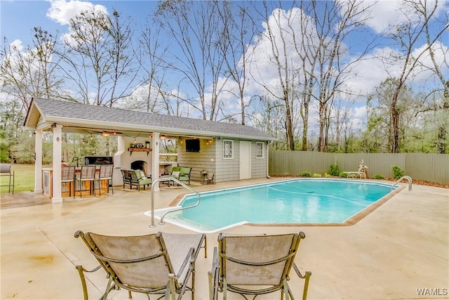 view of swimming pool with a fenced in pool, a patio, outdoor dry bar, fence, and an outdoor structure