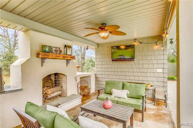 sunroom / solarium with ceiling fan and exterior fireplace