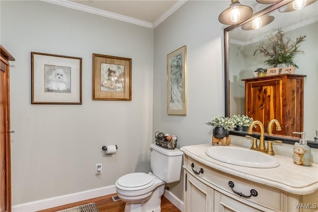 bathroom with baseboards, toilet, wood finished floors, crown molding, and vanity