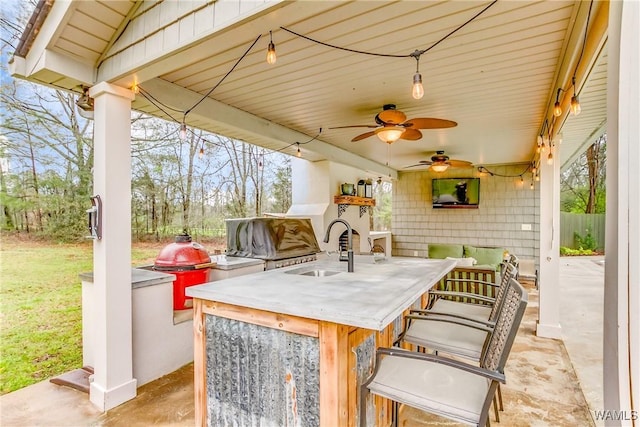 view of patio / terrace with a ceiling fan, a sink, and outdoor wet bar