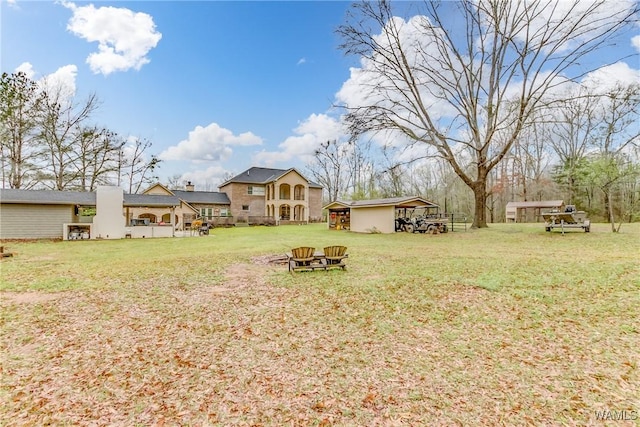 view of yard with a fire pit and an outdoor structure