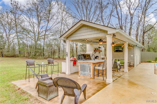 view of patio / terrace with ceiling fan, outdoor dry bar, and fence