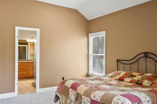 carpeted bedroom featuring ensuite bath, multiple windows, and lofted ceiling