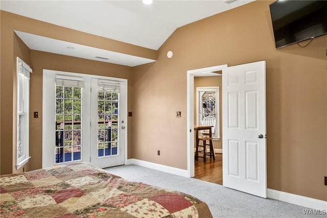 bedroom with access to outside, light carpet, and lofted ceiling