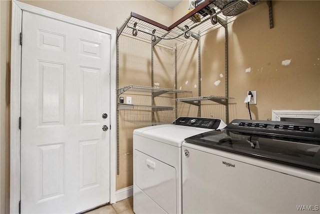 clothes washing area featuring washer and clothes dryer and light tile patterned flooring